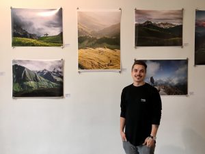 Photographer Bastian Schertel with his Landscape photography on the wall