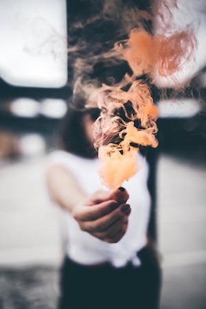 girl with orange smoke in hand