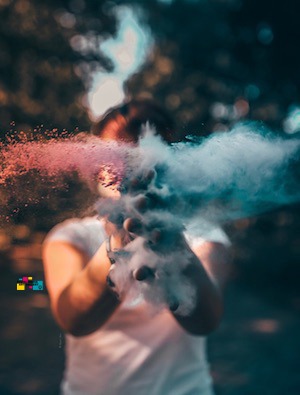 woman claps in hands with colored smoke