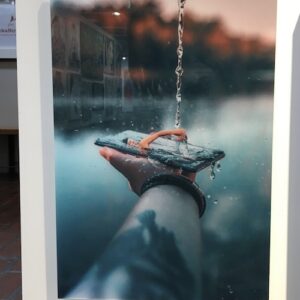 hanging photograph showing man swimming in a mobile phone
