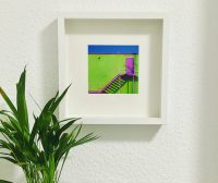 art piece by rusty wiles framed on the wall with deco and plant