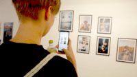 woman talink pictures with iphone of social media artworks