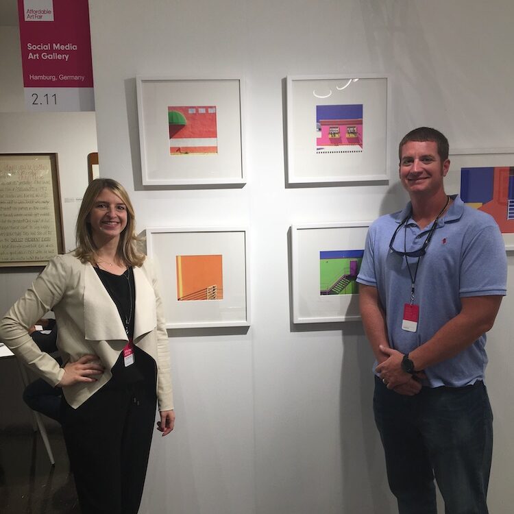 gallery owner anna stoffel meets and greets social media artist rusty wiles in front of his artworks
