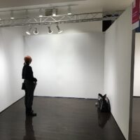 woman standing in empty booth at affordable art fair new york city